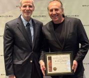 Bruno Basso poses with his Soil Science Research Award in front of a white backdrop.