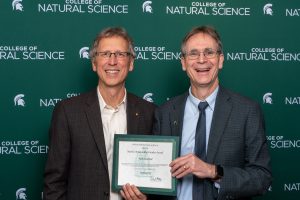 Nick Haddad (left) and Eric Hegg, dean of the MSU College of Natural Science, pose for a picture holding Haddad's certificate for his Outstanding Faculty Award.
