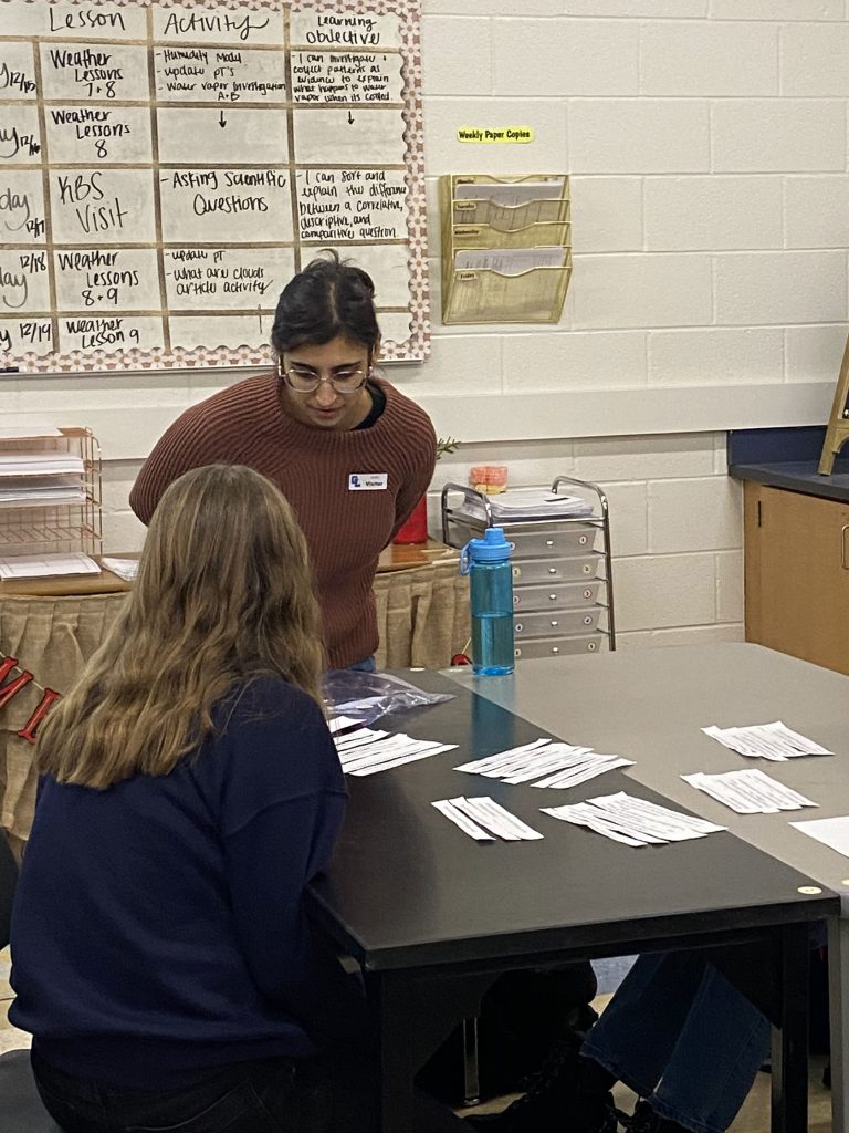 KBS science education and outreach fellow Hannah Rothkopf looks on as a student in a middle-school classroom completes an assignment.