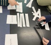 Middle-school students sort pieces of paper with examples of different types of scientific questions during a classroom visit by KBS graduate students.