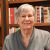 Patricia "Patti" Chipman poses for a photo with shelves filled with books in the background.